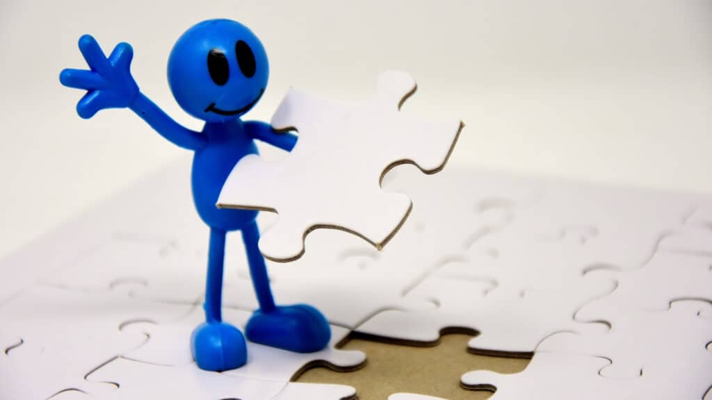 Image of a figure adding a jigsaw puzzle piece